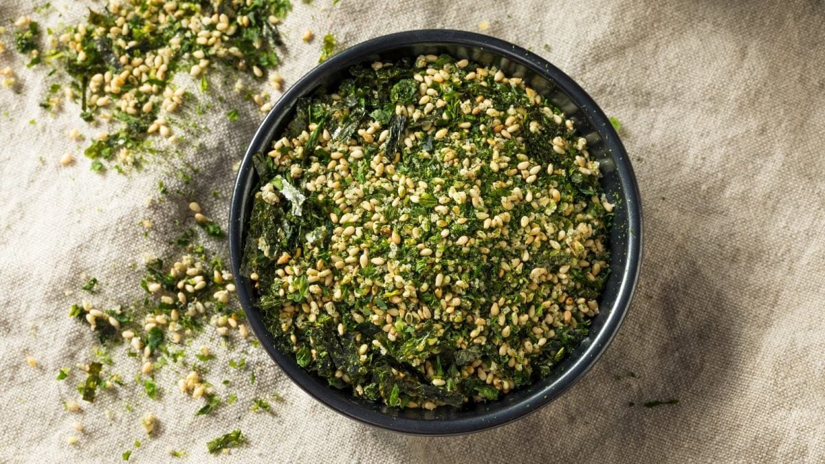 Eine schwarze Schüssel mit Furikake drinnen auf einem Leinentuch.