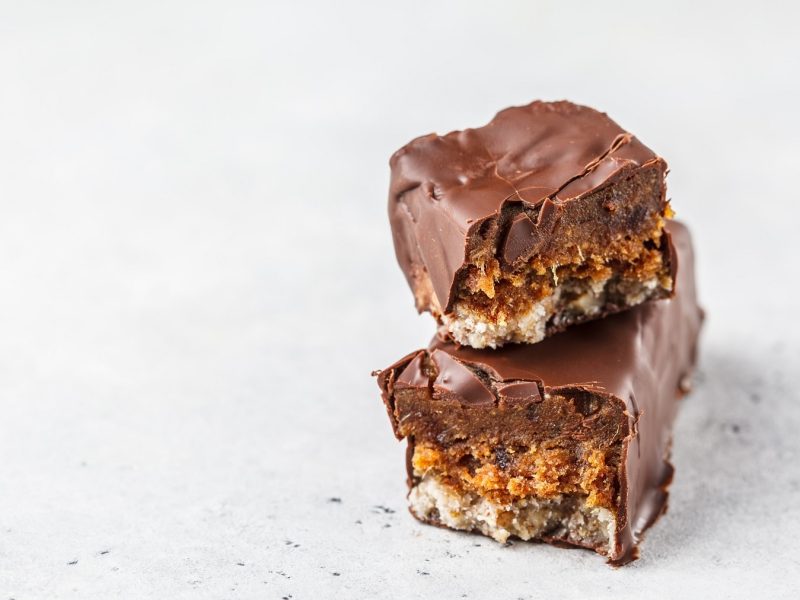 ein durchgebrochener selbst gemachter veganer Snickers übereinander gestapelt.