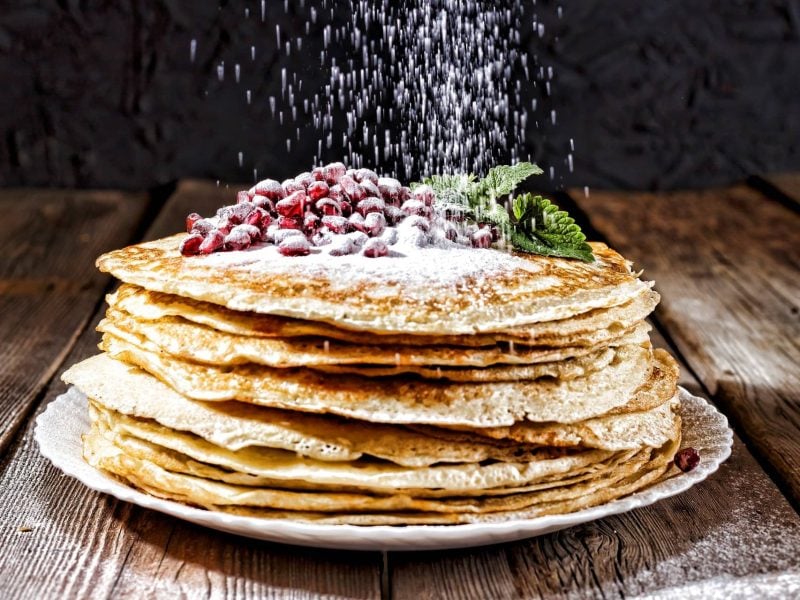 Stapel Pfannkuchen mit Früchten und Puderzucker