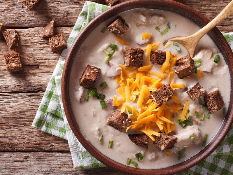 EIne Schüssel mit einer Biersuppe aus der Vorgelperspektice. In der Suppe ist ein Holzlöffel.