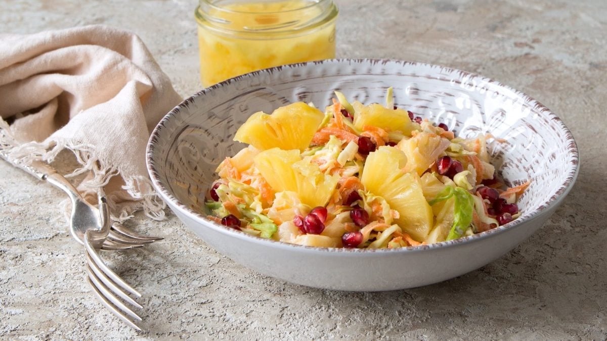 Ein weißer Teller mit Coleslaw auf einem Steinuntergrund.