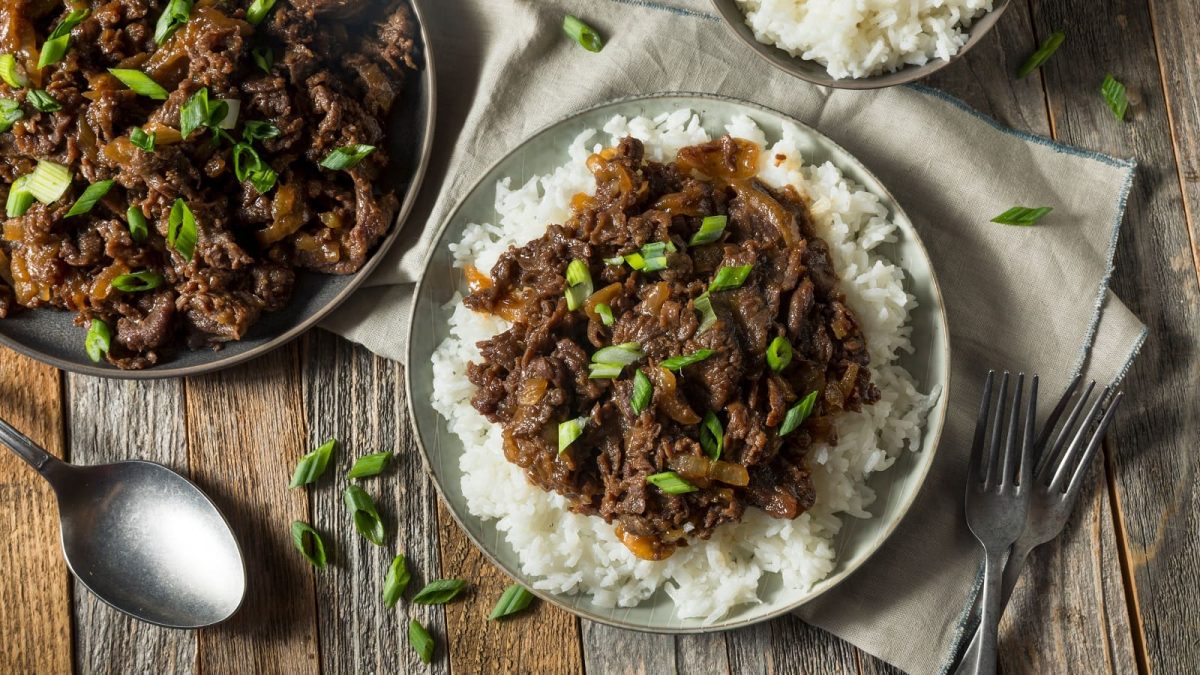 Ein Teller mit Reis und Bulgogi auf einem grauen Tuch.