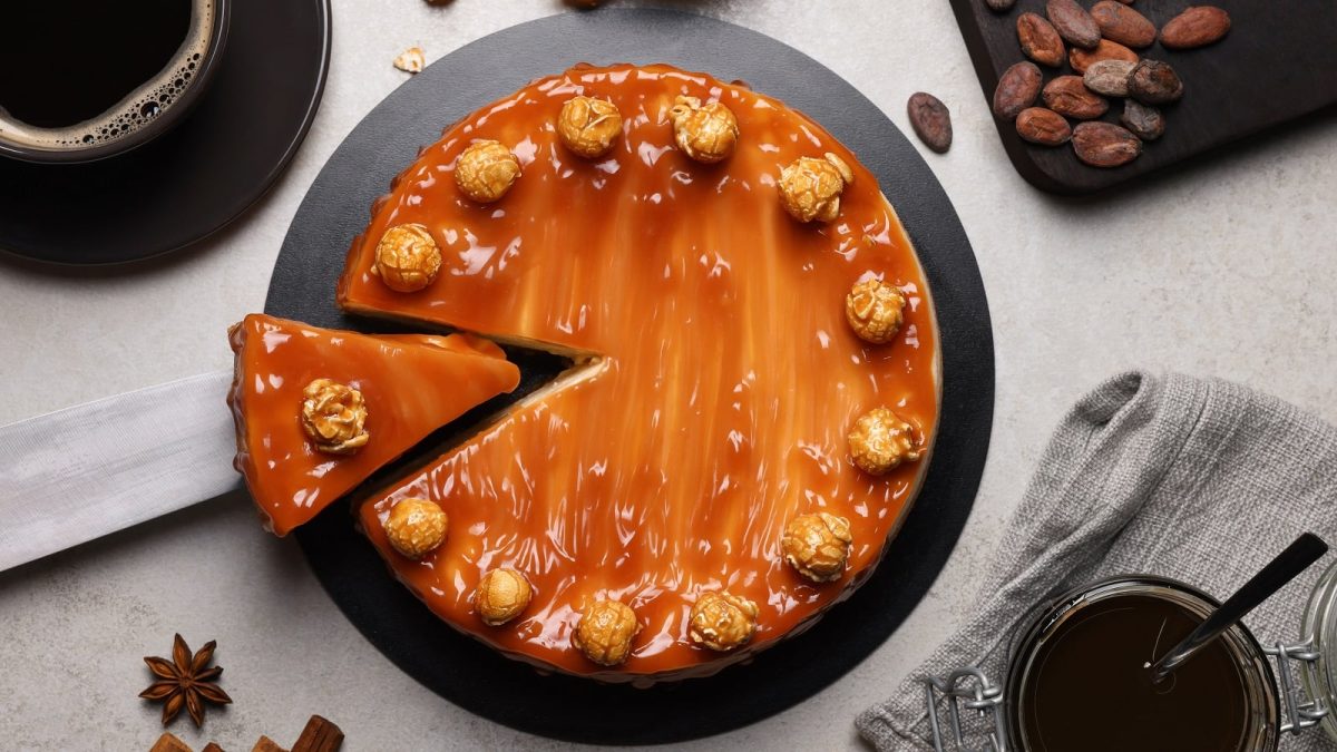 Ein schwarzer Teller mit Karamell-Cheesecake.