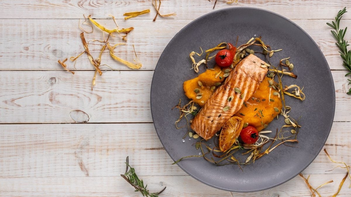 Ein grauer Teller mit Lachs-Steak auf Kürbispüree