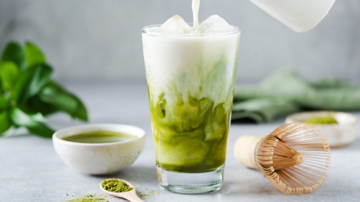 Ein Glas mit Matcha-Kokos-Latte gefüllt.
