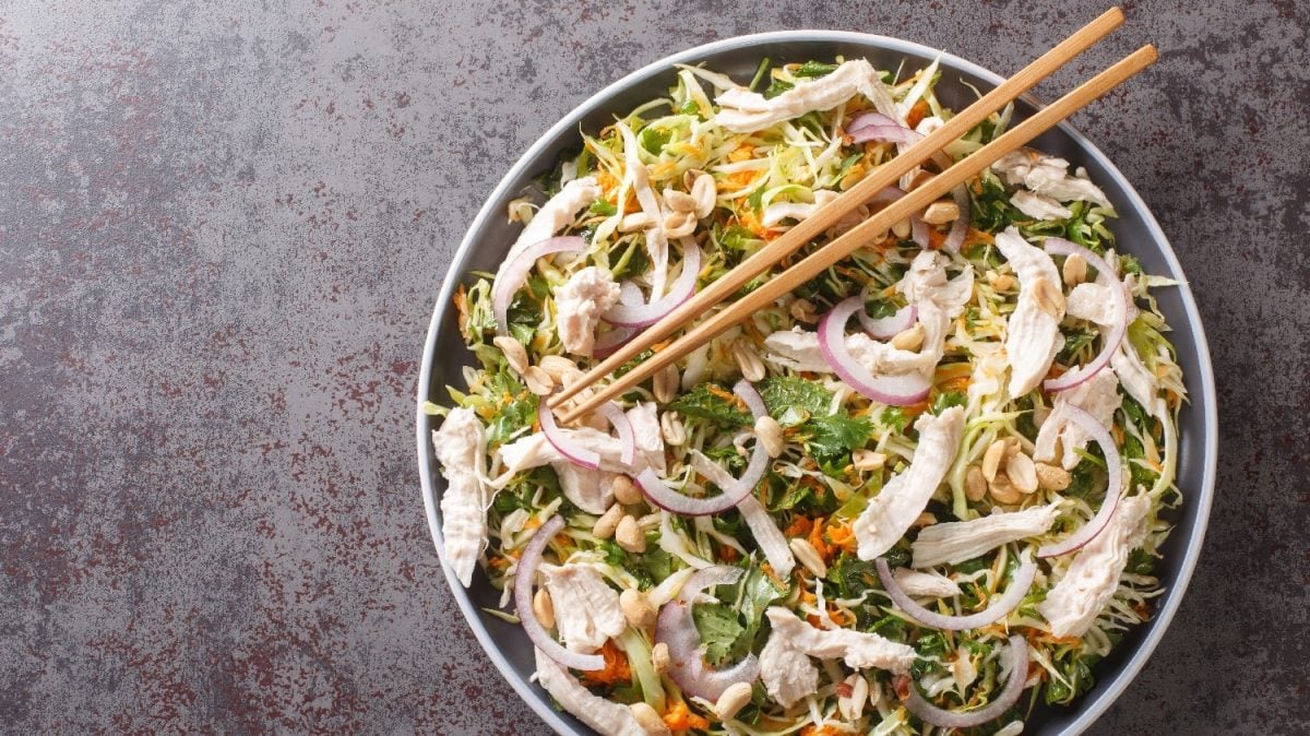 Ein weißer Teller mit dem Goi-Ga-Salat auf einem dunkelgrauen Steinuntergrund.