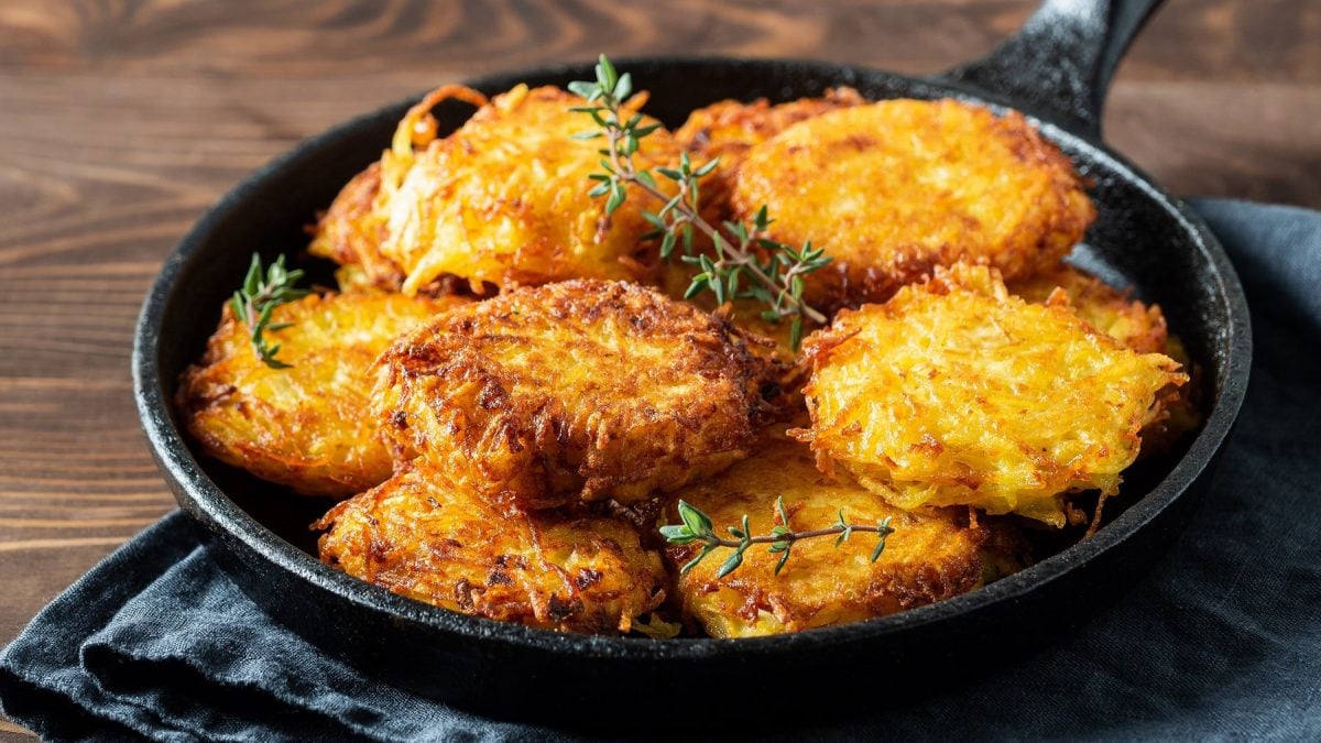 Eine Pfanne Hash Browns mit kräutern.