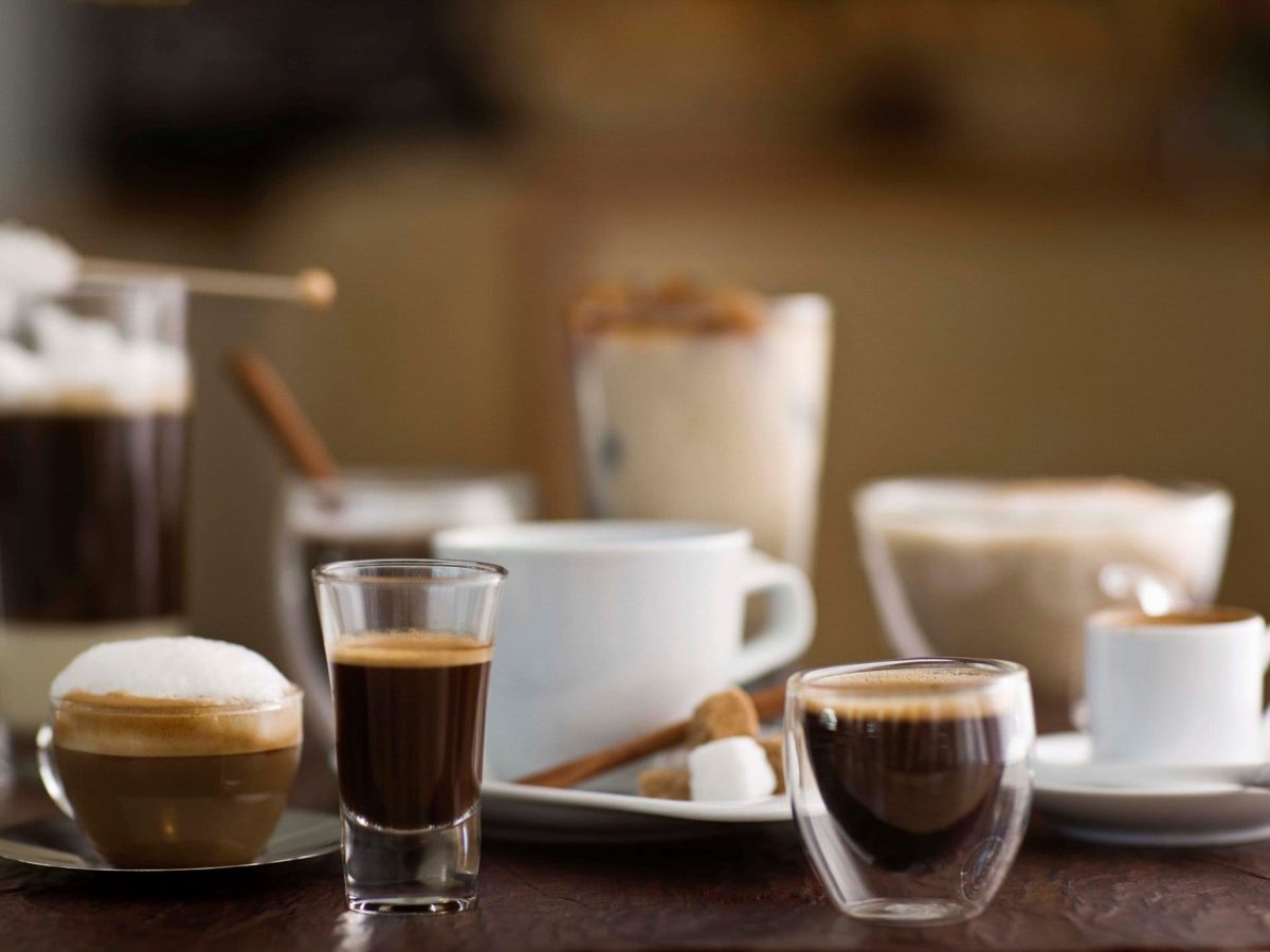Zum Tag des Kaffees diverse Kaffeespezialitäten auf einem Tisch. Frontalansicht.