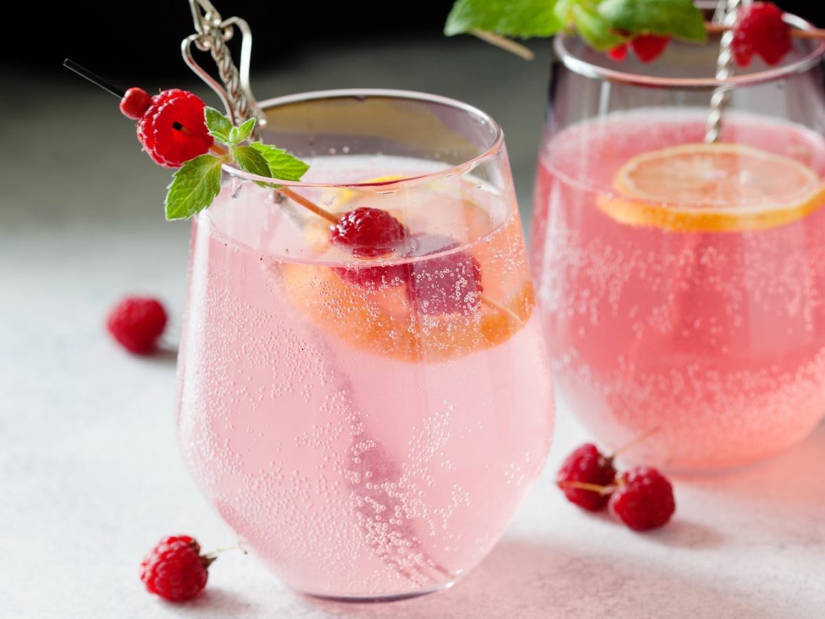 Zwei Gläser Vin Tonic mit TK-Beeren und einer Orangenscheibe.