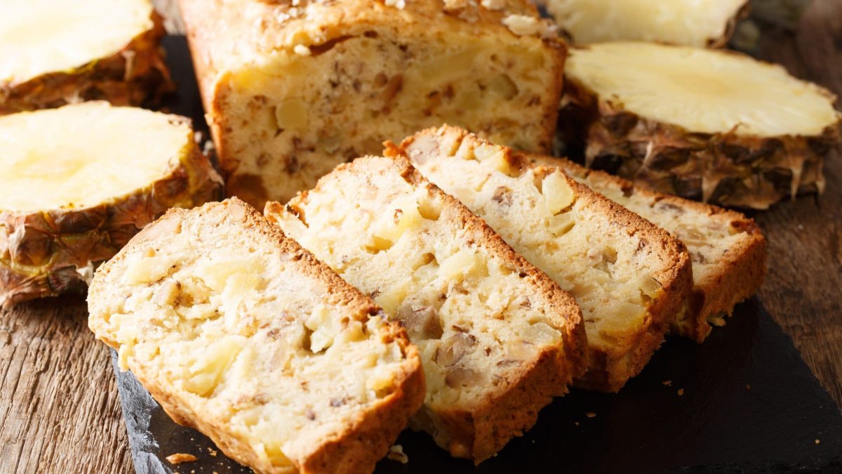 Angeschnittener Ananaskuchen auf Schiefer.