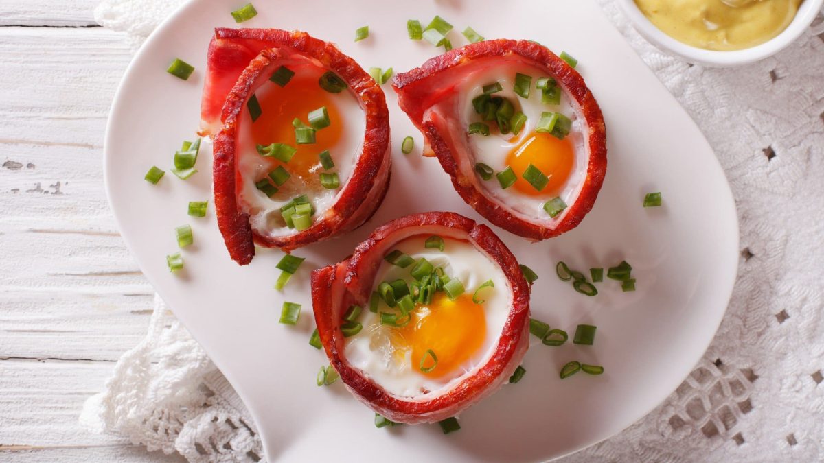 Bacon-Muffins mit Spiegelei auf weißem Teller