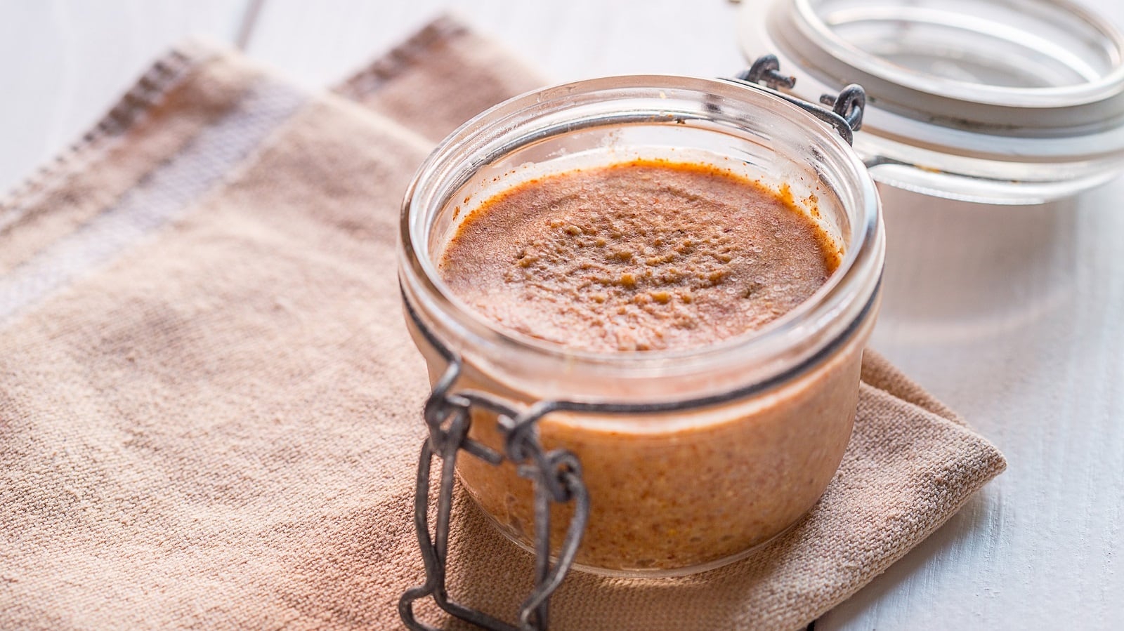 Ein Weckglas mit Apfel-Zimt-Butter auf braunem Tuch