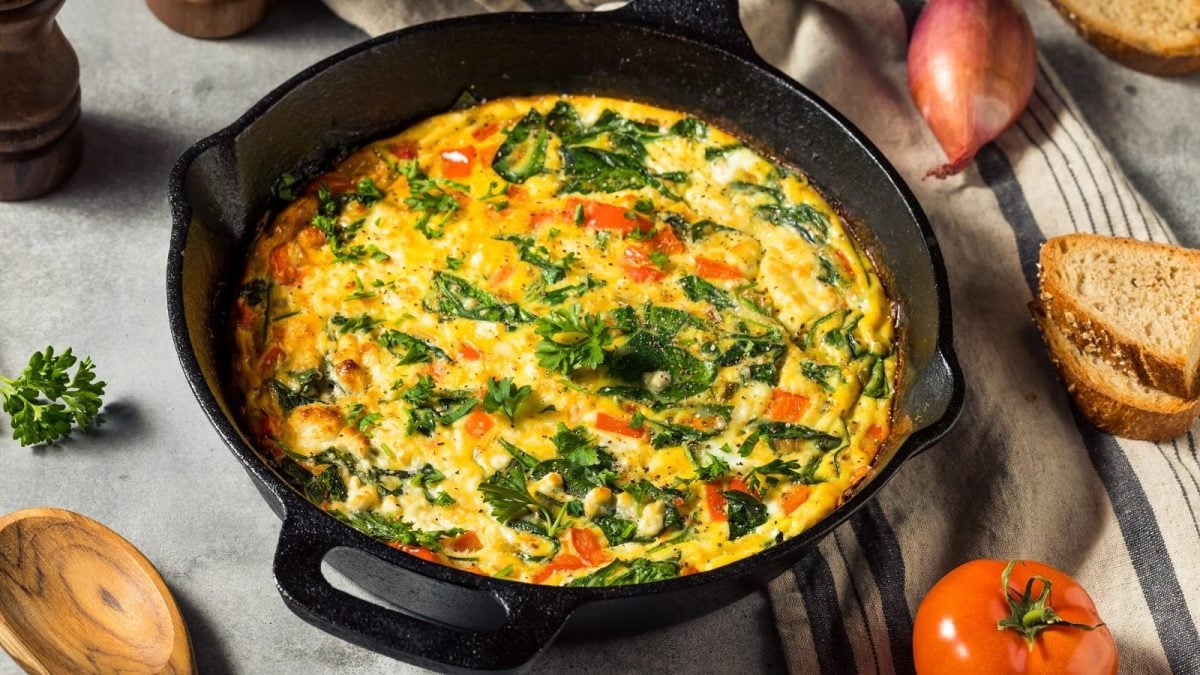 Eine schwarze Pfanne mit Spinat-Frittata mit Feta.