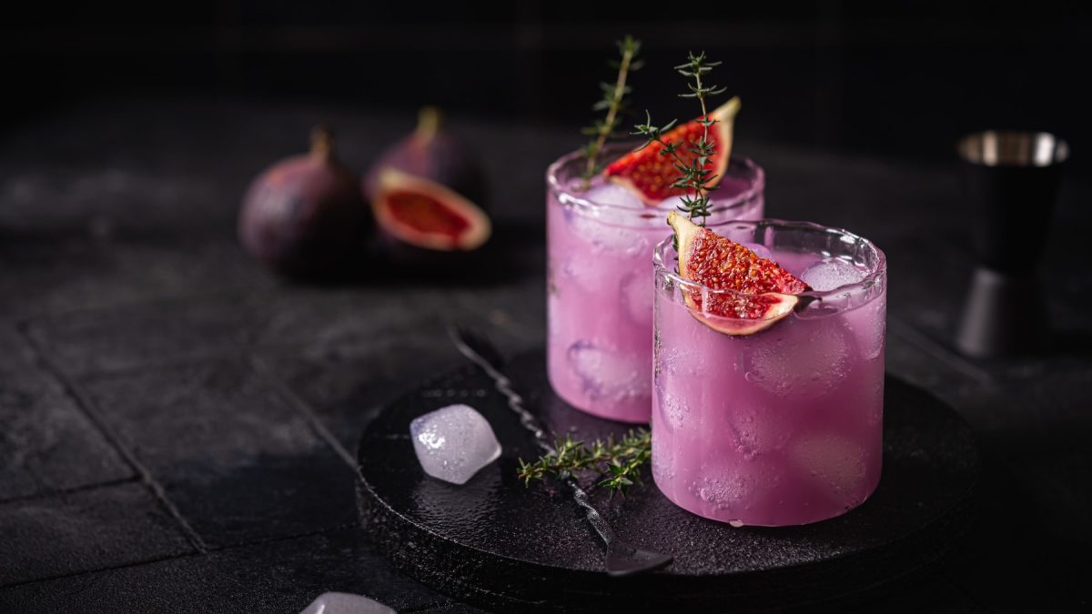 Zwei Gläser mit der violetten Limonade auf einem schwarzen Tisch.