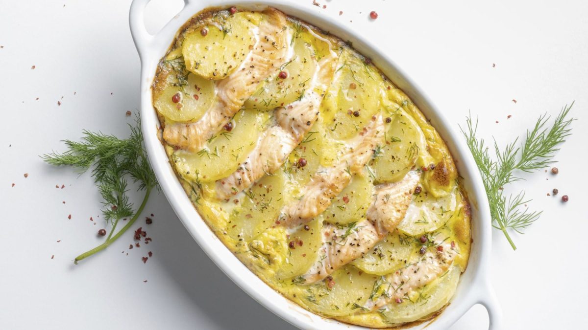 Kartoffel-Lachs-Gratin in ovaler Auflaufform in der Draufsicht.