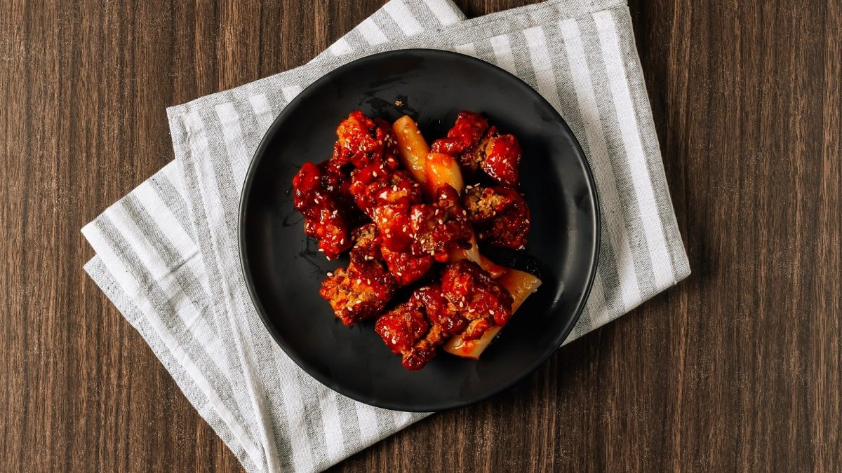 EIn schwarzer Teller mit Yangyeom Tofu darauf auf einem Küchentuch.