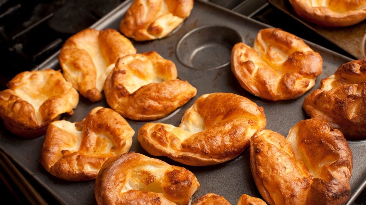 Yorkshire Pudding in einer Muffinform vor schwarzem Hintergrund.