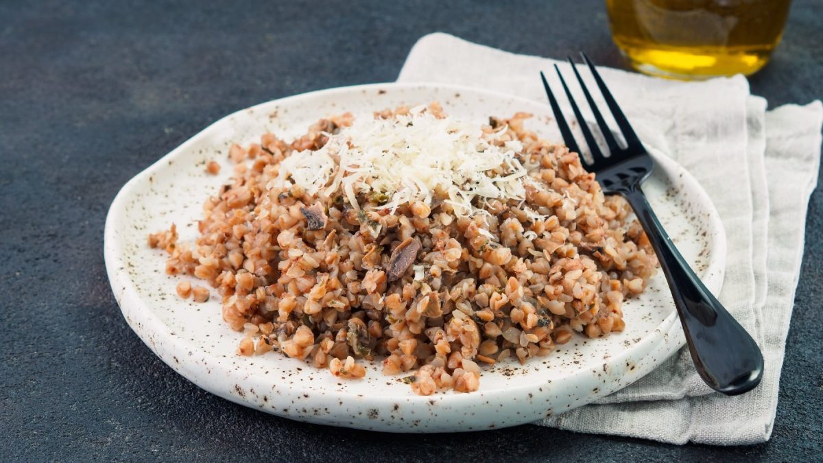 Ein weißer, dicker Teller mit dem Buchweizenrisotto und Käse.