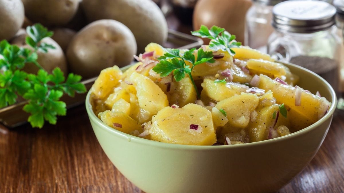 Eine Schüssel französischer Kartoffelsalat mit roten Zwiebeln und Petersilie.