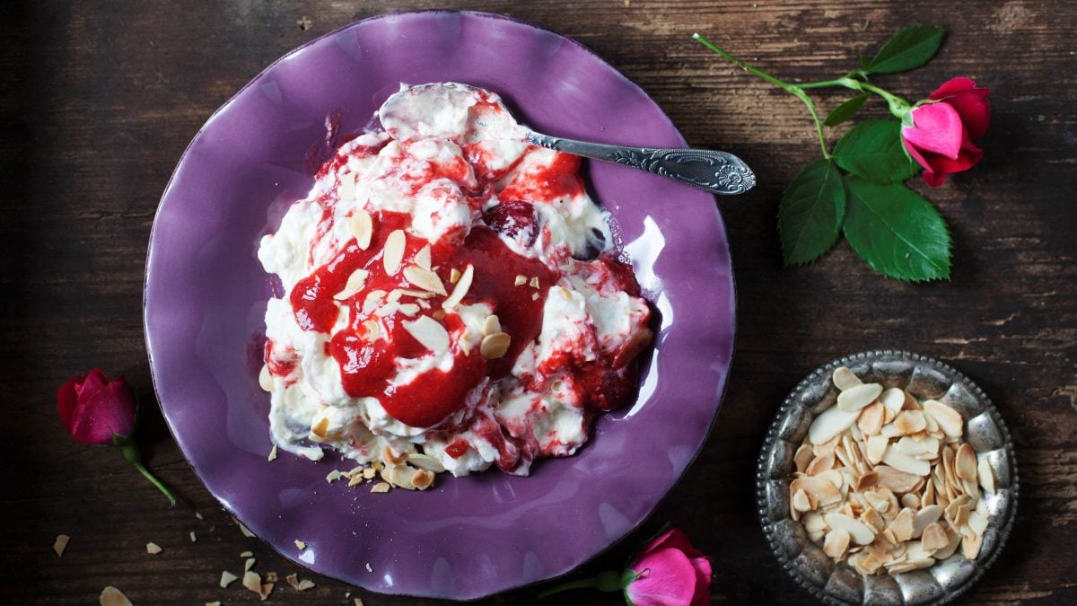 Erdbeer-Baiser-Dessert auf lila Teller.
