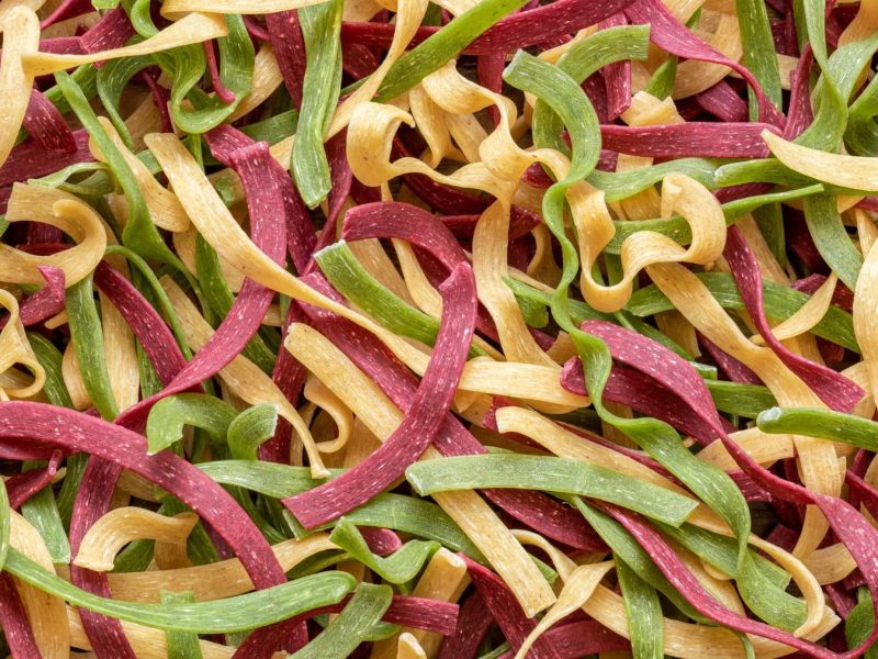 Bunte Pasta selbst machen - viele Tagliatelle in rot, gelb und grün.