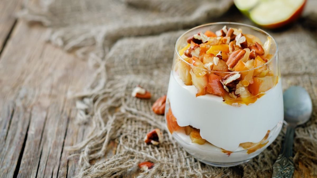 Ein kleines Gläschen mit Apfel-Joghurt-Creme auf einem Stofftuch.