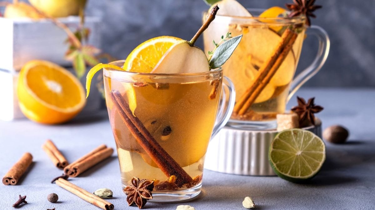 Zwei Gläser mit Birnen-Glühwein auf einem weißen Tisch.