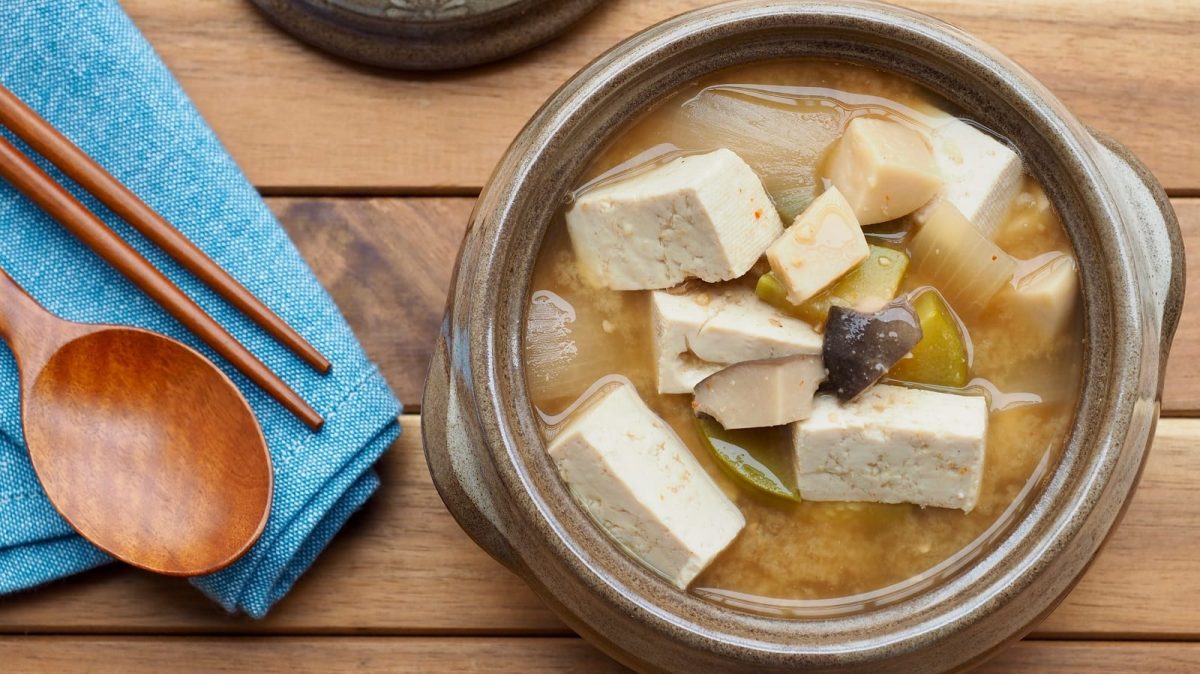 Eine Schüssel mit Doenjang Jjigae auf einem Holztisch.