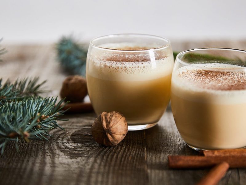 Zwei Gläser mit Eggnog Latte auf einem Holztisch.