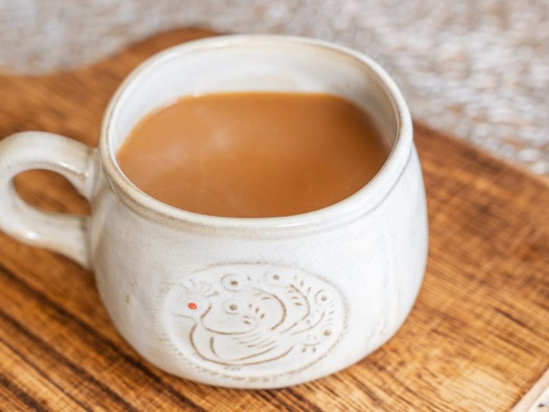 Eine Tasse mit Hong Kong Milk Tea auf einem Brett.