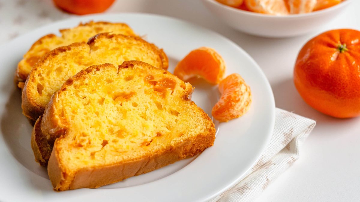 Drei Stücke des Mandarinenkuchens auf einem weißen Teller.