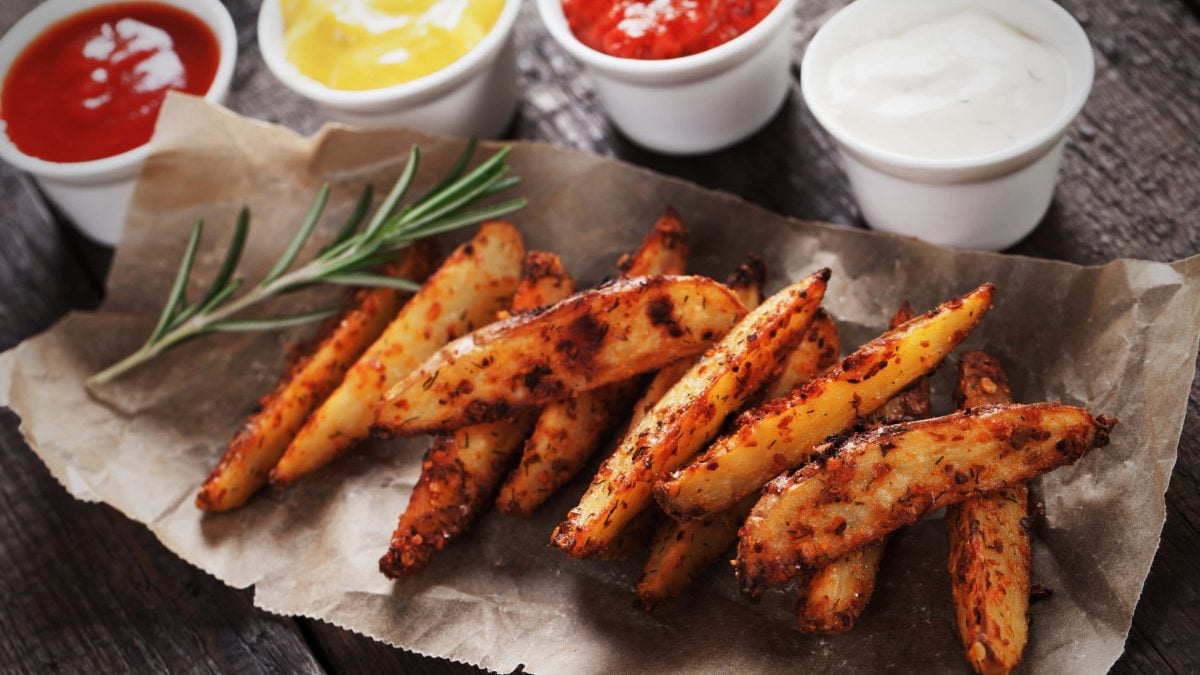 Roasted Garlic Wedges Hot and Spicy mit Dips auf Backpapier. Draufsicht