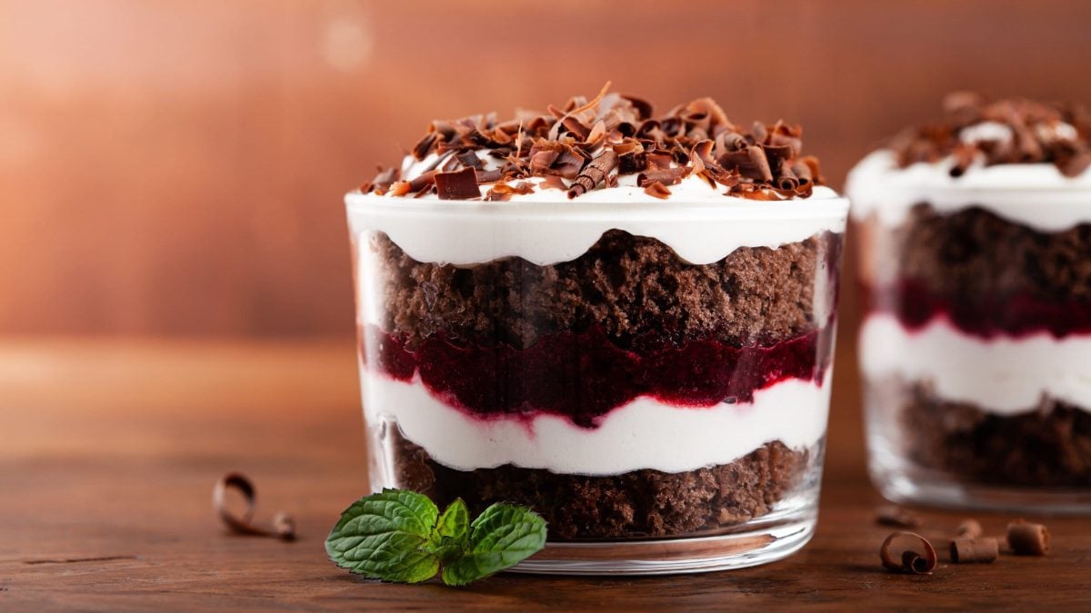 Zwei Schwarzwälder Kirschtorten im Glas, dunkler Kuchenboden, Kirschen und weiße Creme geschichtet und getoppt mit Schokoraspeln.