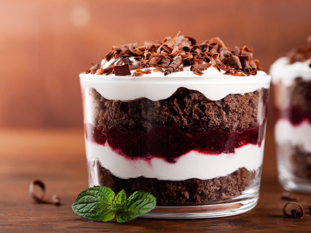 Zwei Schwarzwälder Kirschtorten im Glas, dunkler Kuchenboden, Kirschen und weiße Creme geschichtet und getoppt mit Schokoraspeln.