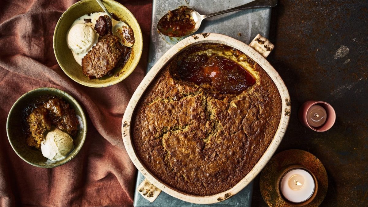 Draufsicht: Auflaufform mit self-saucing sticky Lebkuchen-Pudding. Zwei Teller angerichtet mit Pudding und Vanilleeis