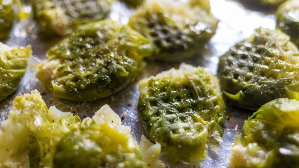Smashed Rosenkohl-Köpfe auf einem Blech.