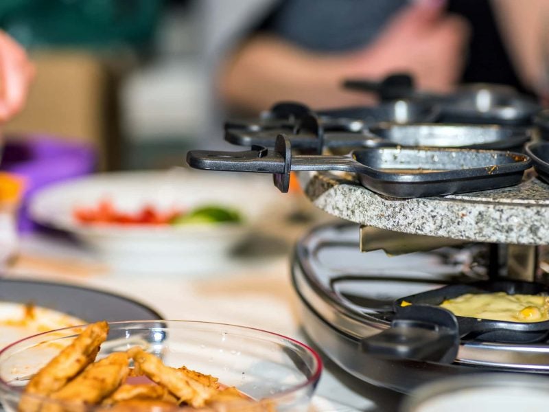 süßes Raclette: ein Raclettegrill mit kleinen Pfannen darin und darauf.