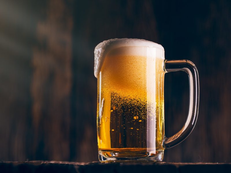 Stimmungsvolle Aufnahme eines Lagerbiers in einem großen Bierkrug schräg von unten fotografiert.