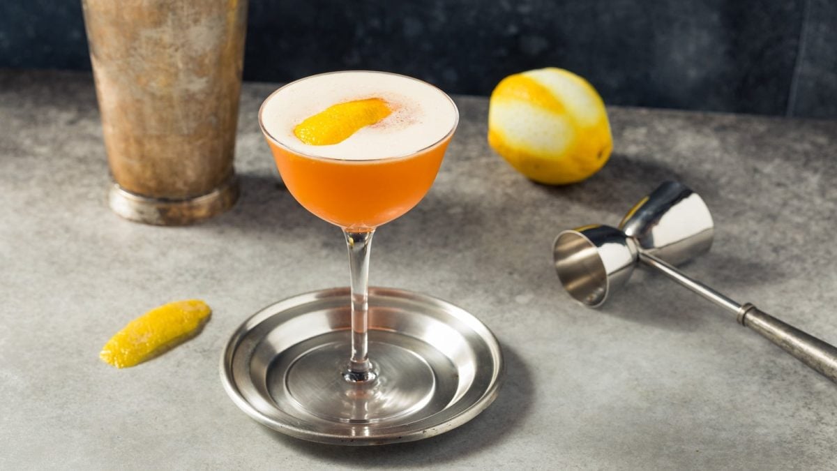 Ein Glas mit Earl Grey Martini neben frischen Zitronen.