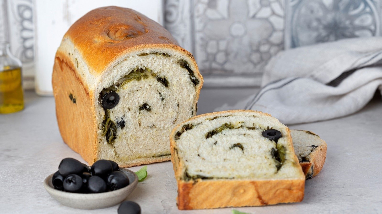 Ein Laib Spinatbrot mit Oliven.