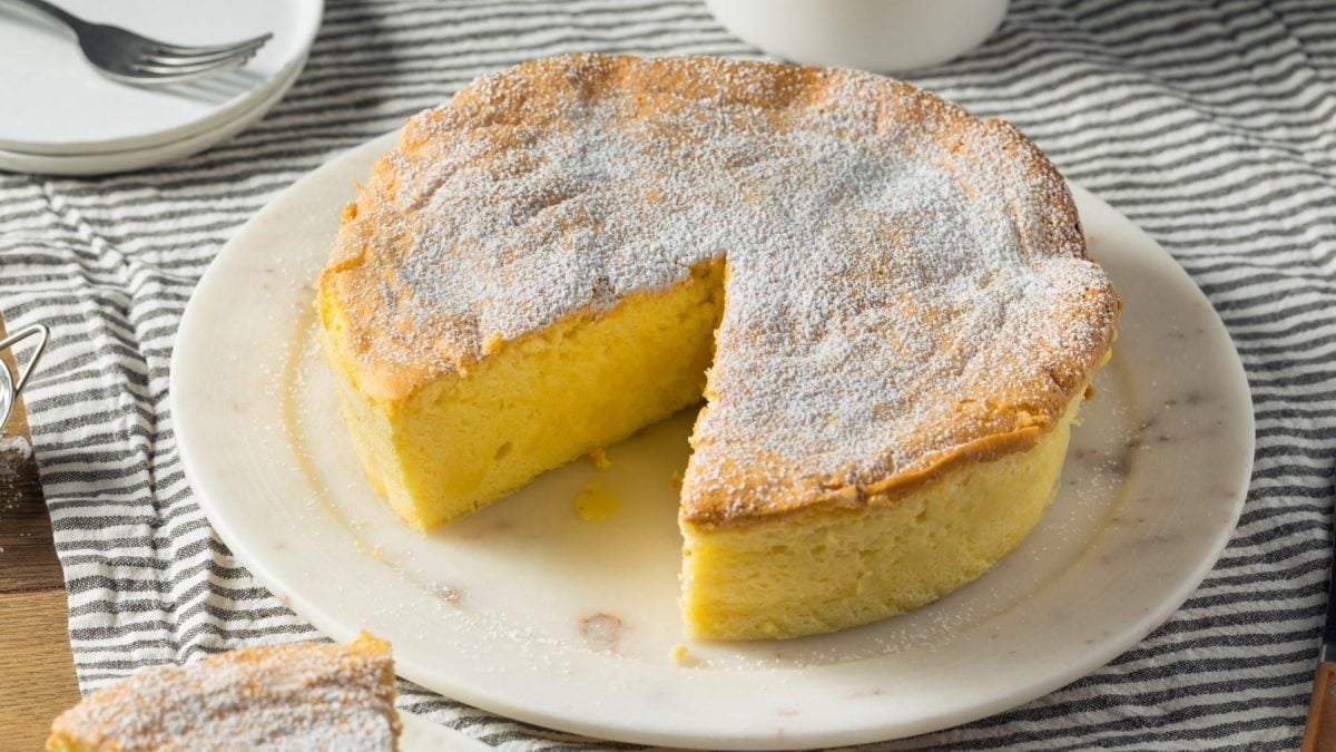 Japanischer Soufflé Käsekuchen mit Puderzucker angeschnitten auf einem weißen Teller.