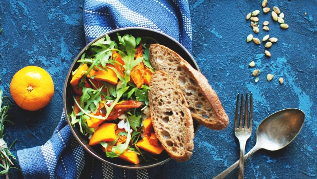 Eine Schale mit dem Salat auf blauem Untergrund.