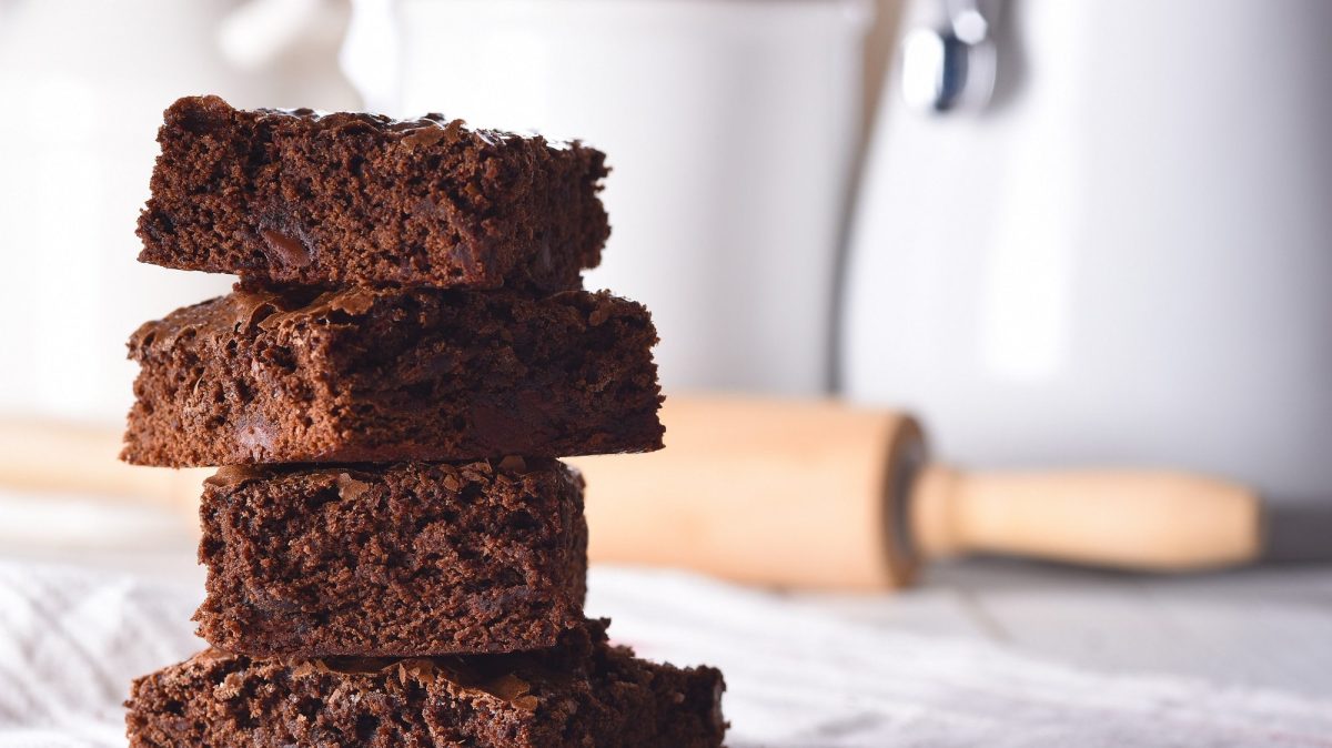 Ein Stapel Oreo-Brownies, dahinter unscharf ein Nudelholz.