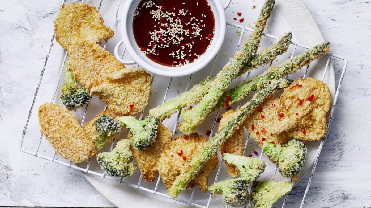 Sriracha-Gemüse-Tempura, serviert mit einer scharfen Sauce auf einem großen Backblech.