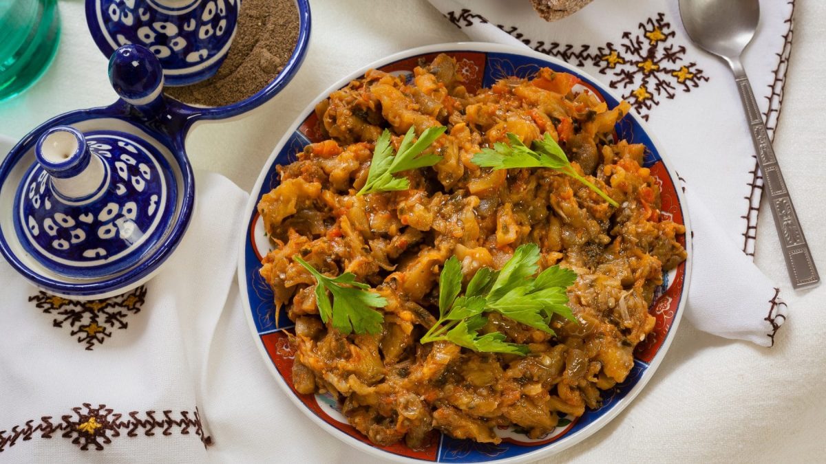 Zaalouk warmer marokkanischer Auberginensalat in Schale auf Tischtuch. Im Bild traditionelles Geschirr. Draufsicht.