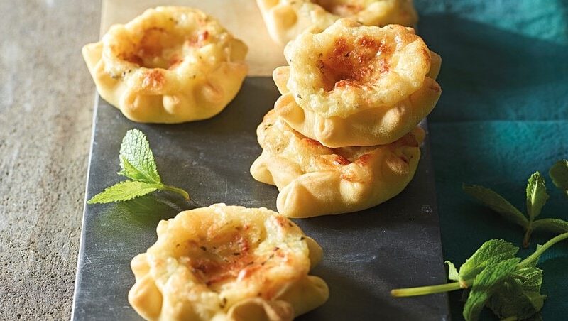 Auf einer Platte liegen vier Grießsterne mit Kartoffel-Pecorino-Füllung. Sie sind golbraun gebacken.