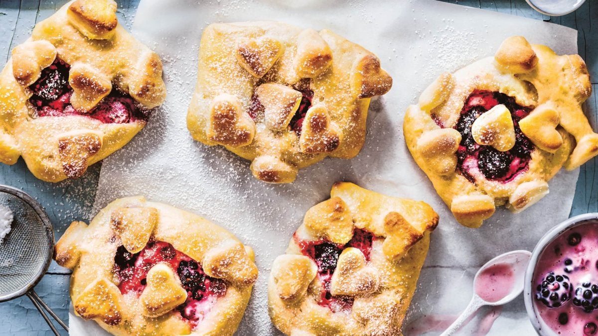 Draufsicht: Quarktaschen mit Beeren-Brandy-Creme liegen auf einem Backblech.