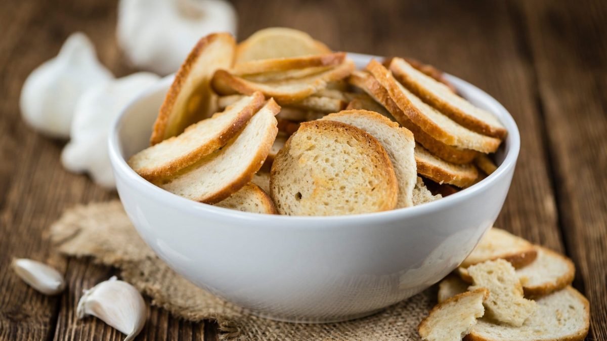 Eine Schale Brezel-Chips, daneben Knoblauch.