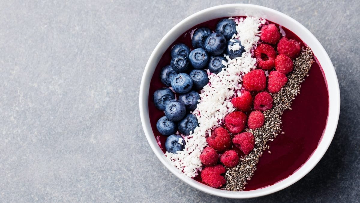 Eine weiße Schale mit der Drachenfrucht-Bowl auf einem grauen Untergrund.