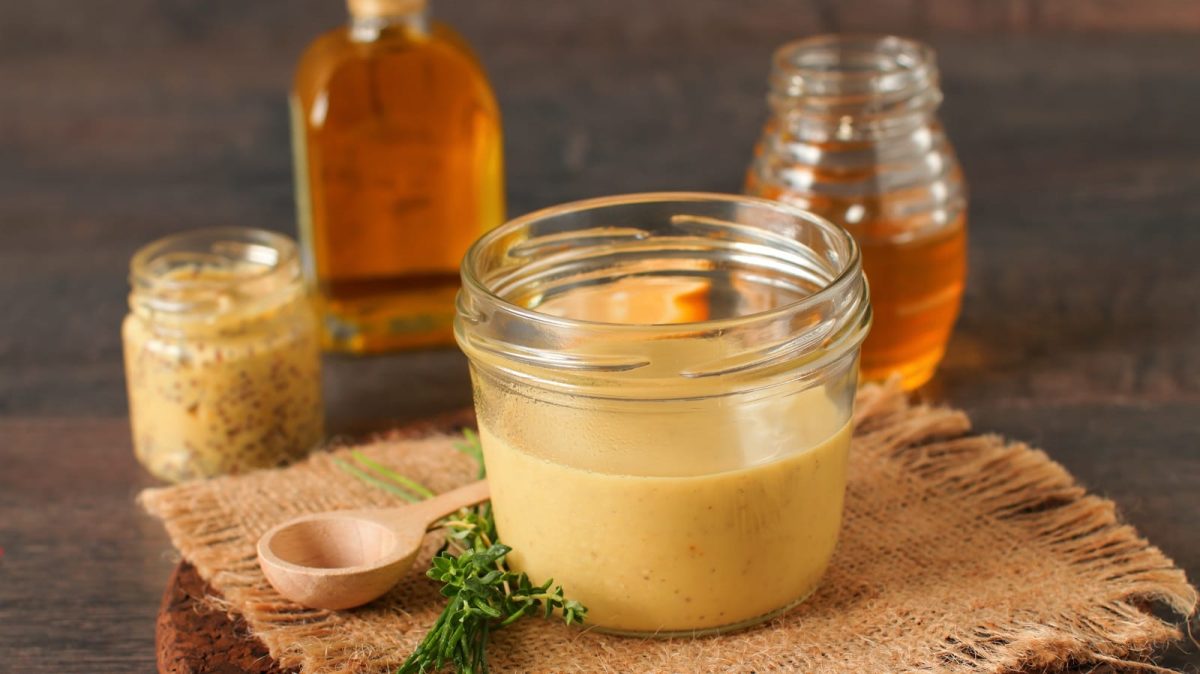 Ein Glas mit Ahornsirup-Vinaigrette auf einem Tuch.